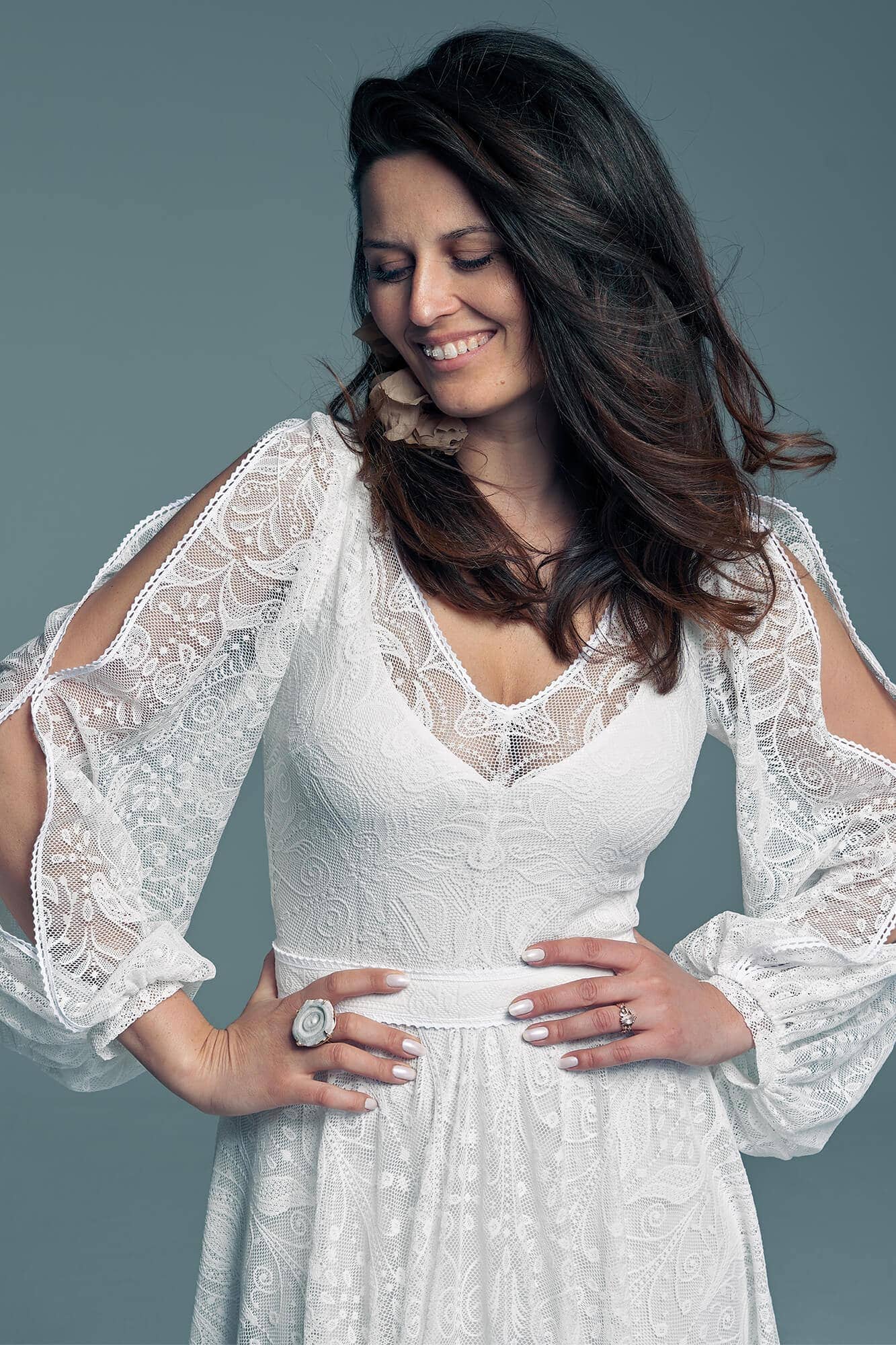 Suknia ślubna z długimi, koronkowymi rękawami i dekoltem w kształcie litery V.