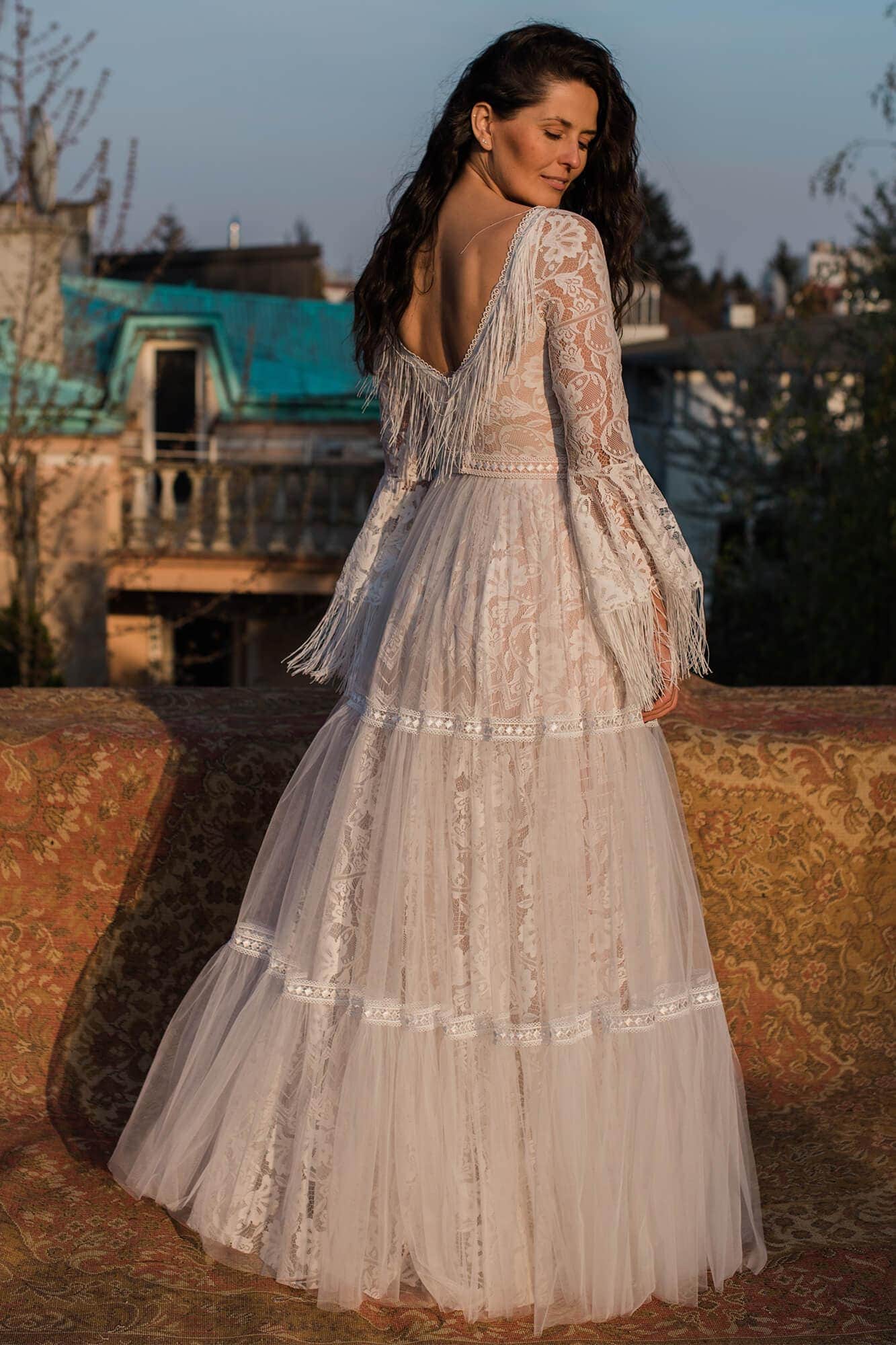 suknia ślubna z długimi rękawami, koronkowym wykończeniem i warstwowym dołem, widok z tyłu