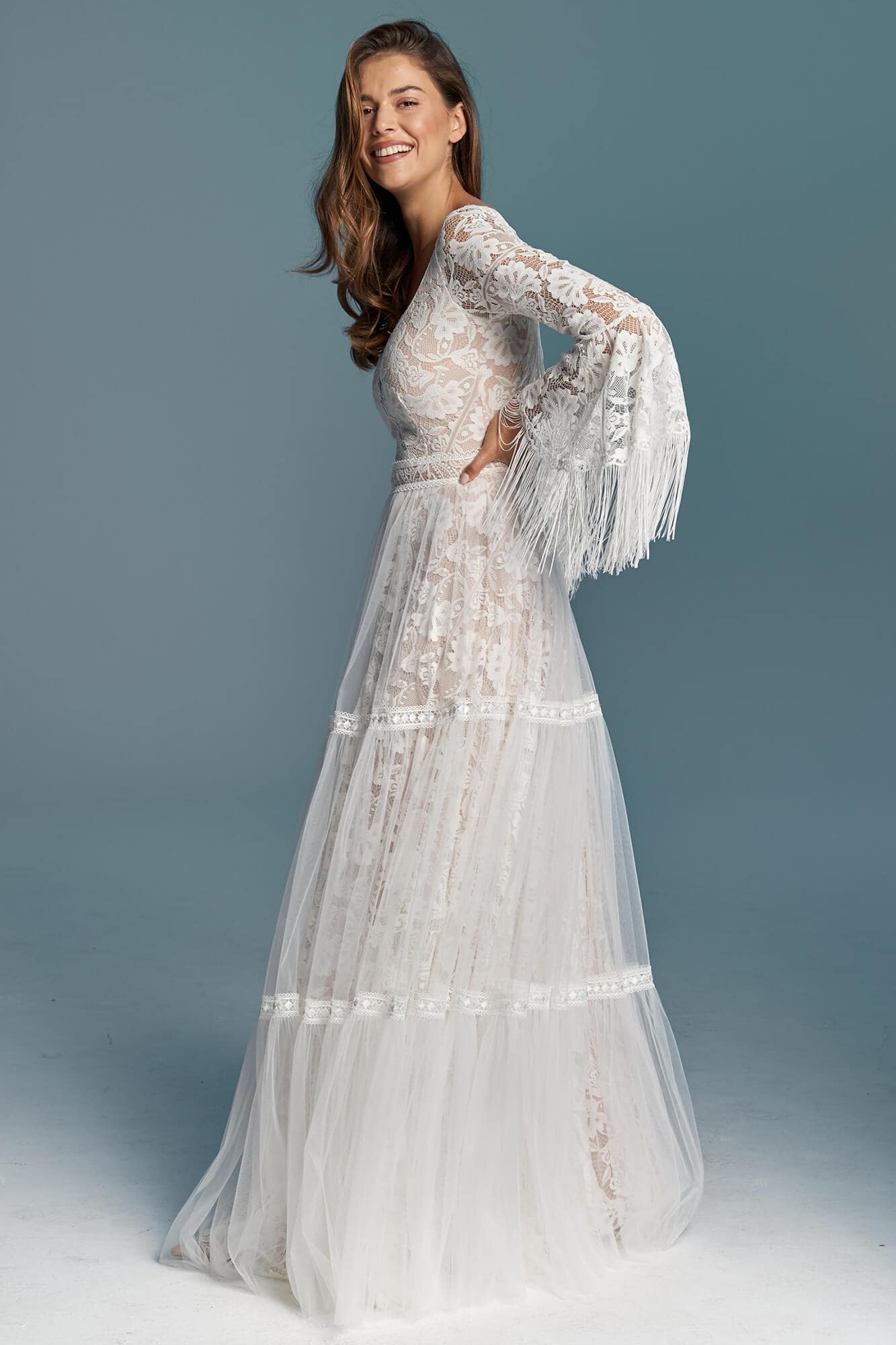 suknia ślubna z długimi rękawami i koronkowym wykończeniem, w kolorze białym.