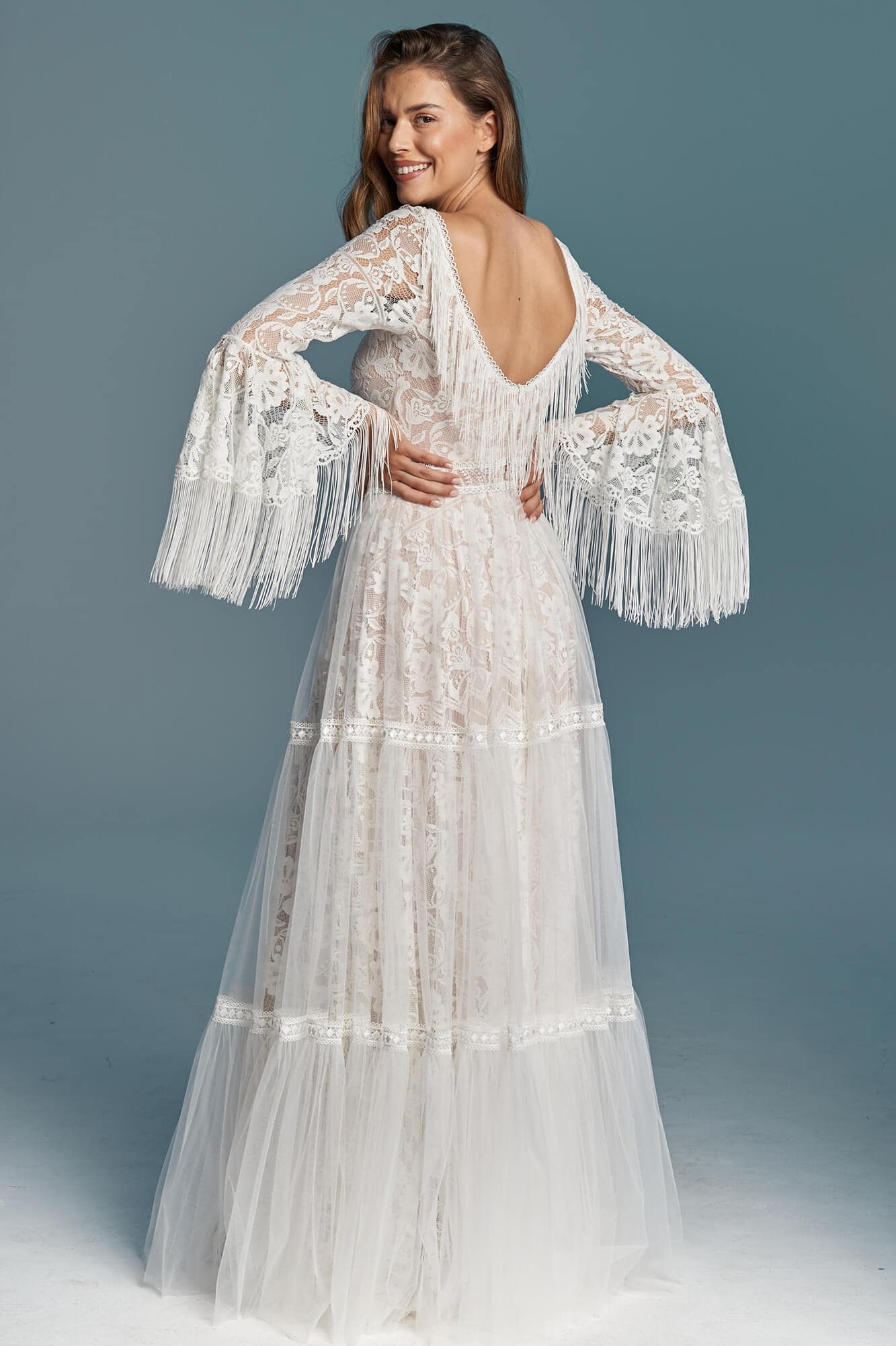 suknia ślubna z długimi koronkowymi rękawami i frędzlami, z odkrytymi plecami i tiulowym dołem