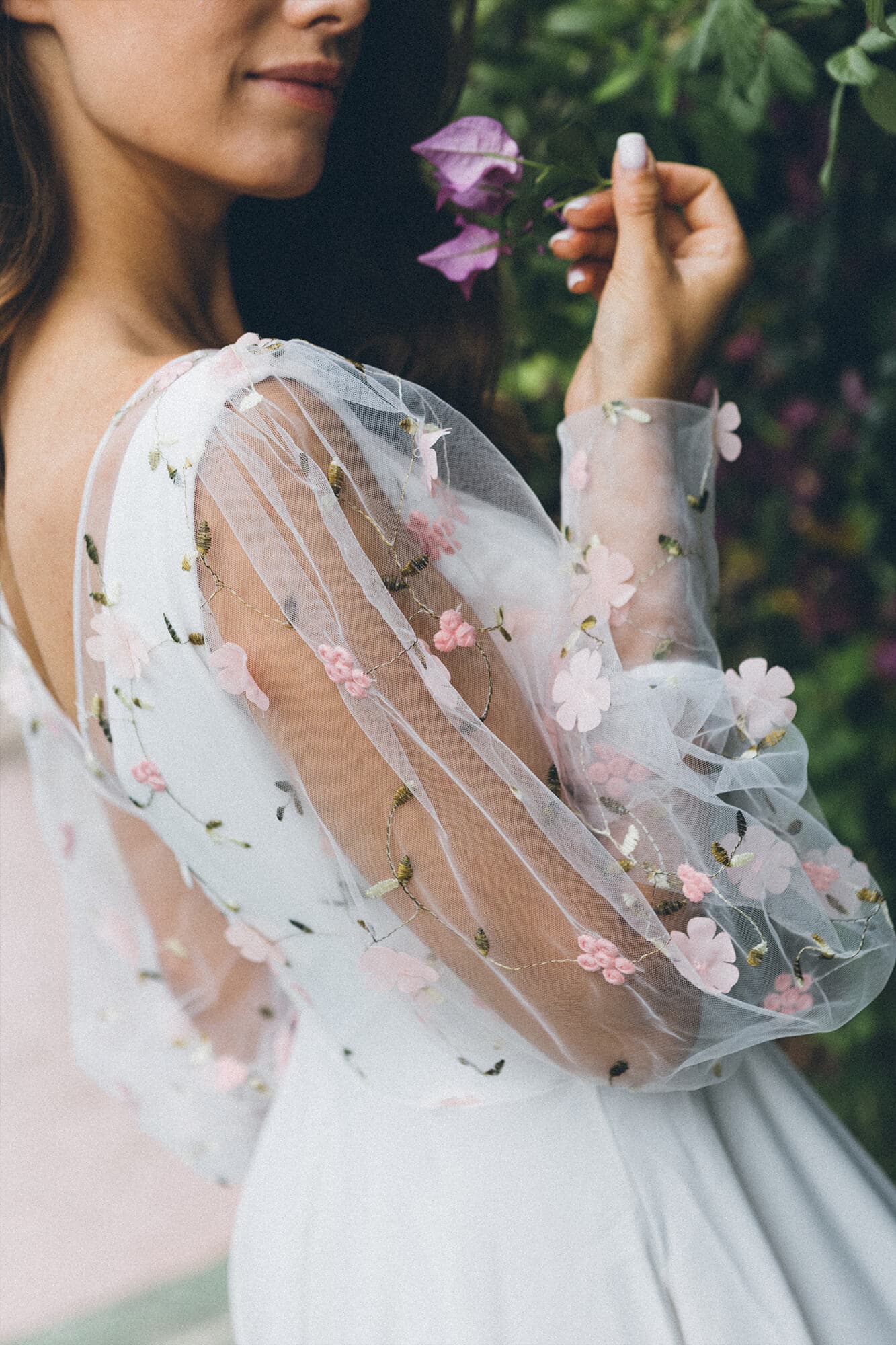 suknia ślubna z przezroczystymi rękawami ozdobionymi różowymi kwiatami