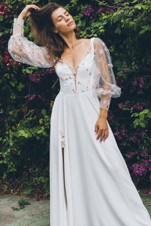 suknia ślubna z długimi, przezroczystymi rękawami ozdobionymi kwiatowymi haftami, w kolorze białym