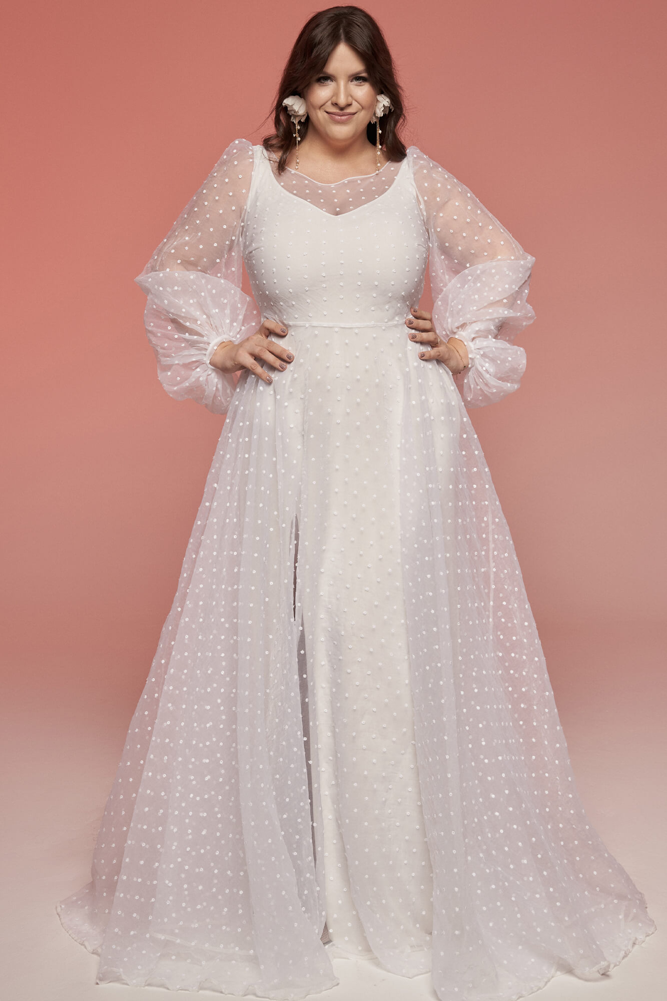 suknia ślubna z długimi, transparentnymi rękawami i koronkowym wykończeniem, w kolorze białym.