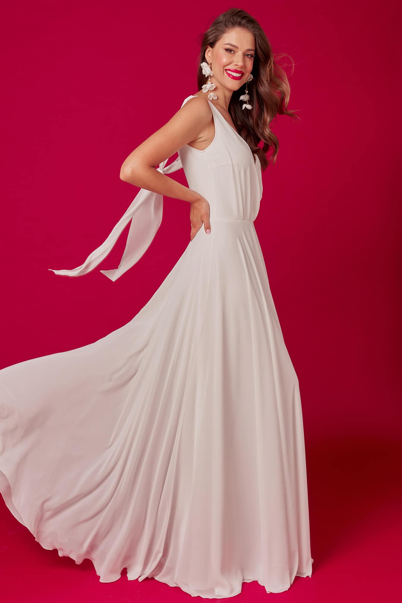 suknia ślubna w kolorze białym z długim, zwiewnym dołem i wiązaniami na ramionach