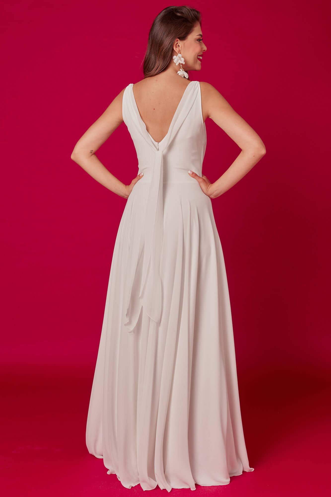 suknia ślubna o głębokim dekolcie i odkrytych plecach, w kolorze jasnym, z długim dołem.