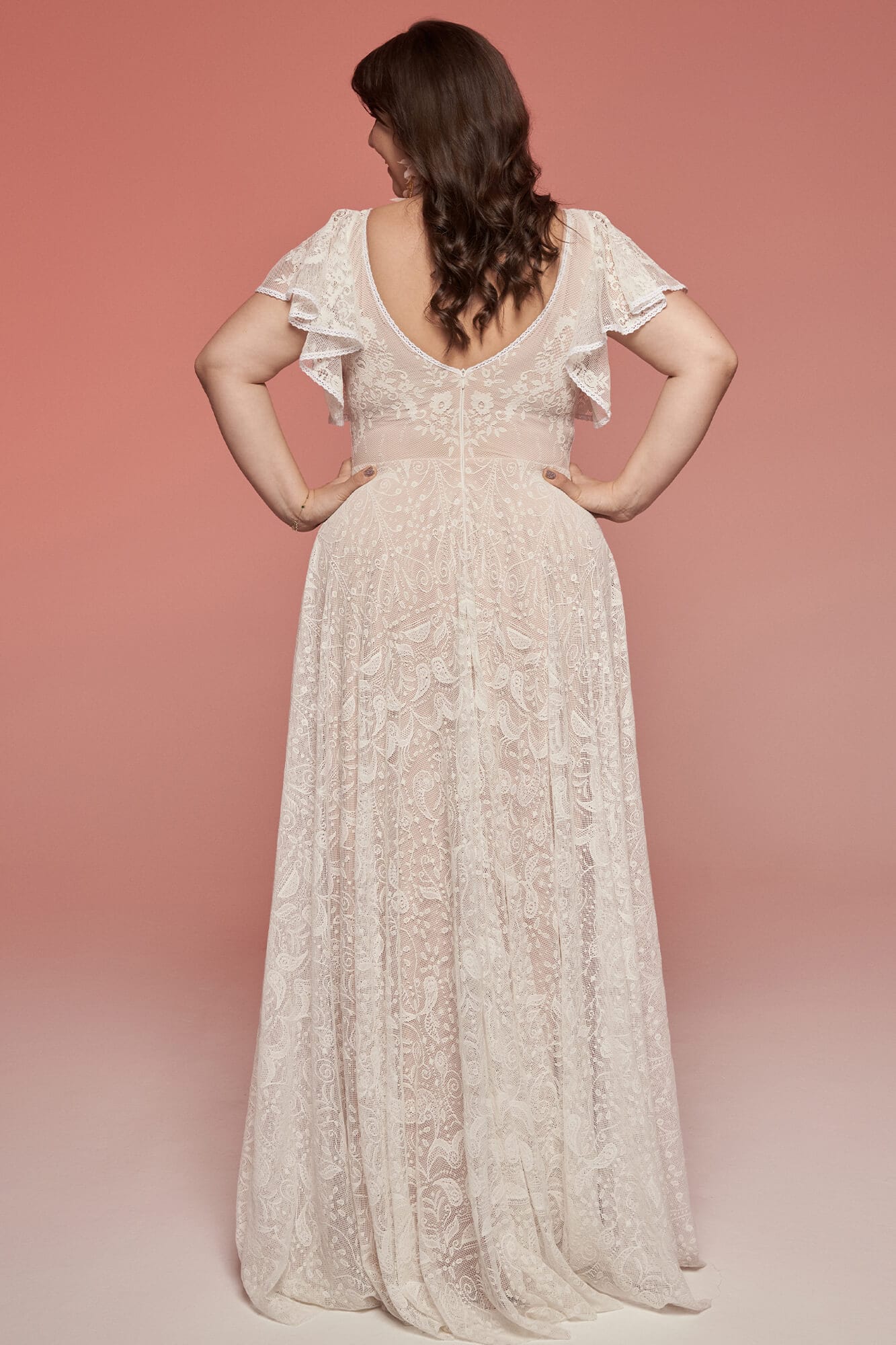 suknia ślubna z długim, zwiewnym dołem i odkrytymi plecami, z falbaniastymi rękawami.