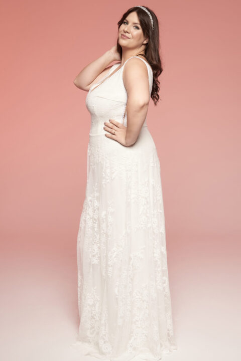 suknia ślubna z koronkowymi detalami, bez rękawów, na tle różowego tła