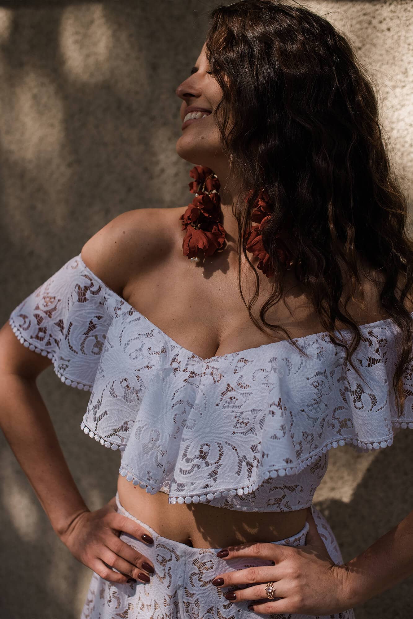 suknia z koronkowym dekoltem i falbanami na rękawach, z długimi, czerwonymi kolczykami