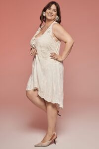 suknia w kolorze jasnym, z koronkowymi detalami, o asymetrycznym kroju i ramiączkach