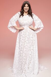 suknia ślubna z długimi rękawami, wykonana z koronkowego materiału, w kolorze białym