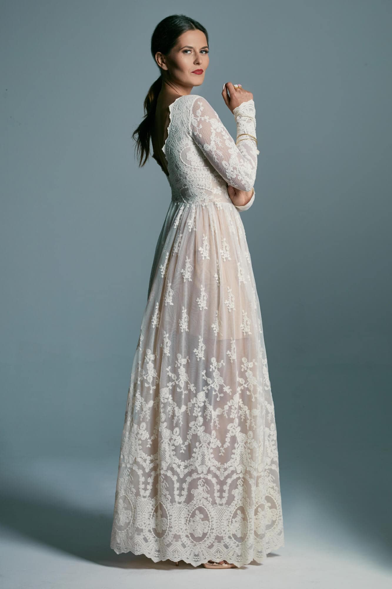 suknia ślubna z długimi rękawami, koronkowym wzorem i przezroczystym materiałem w dolnej części