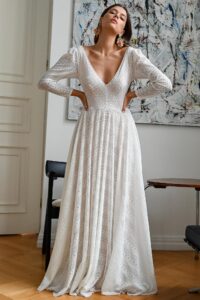 suknia ślubna z długimi rękawami, dekoltem w serek i plisowanym dołem w jasnym kolorze