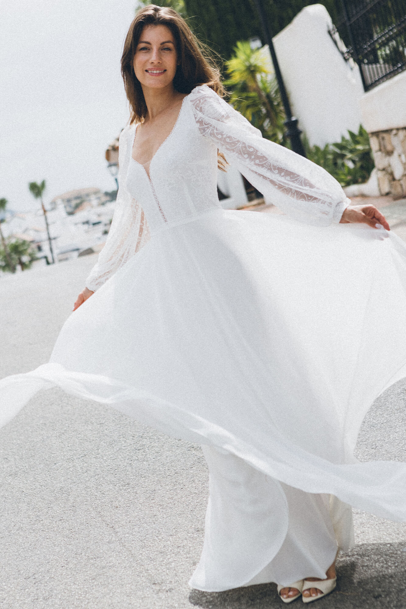 suknia ślubna z długimi, zwiewnymi rękawami i rozkloszowanym dołem, w kolorze białym