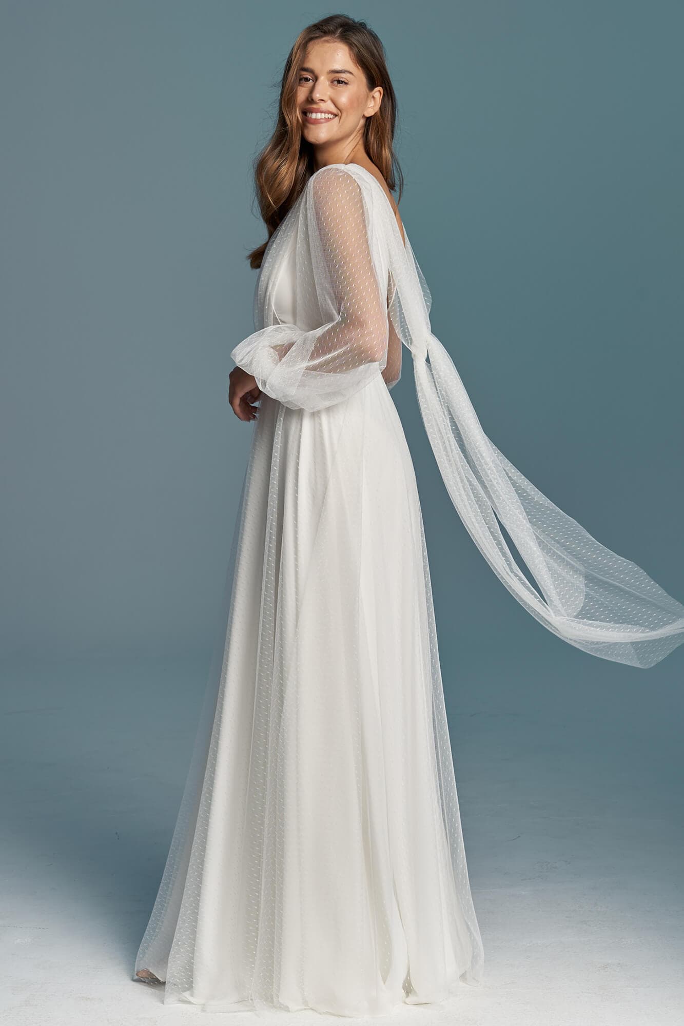 suknia ślubna z długimi, transparentnymi rękawami i delikatnym trenem