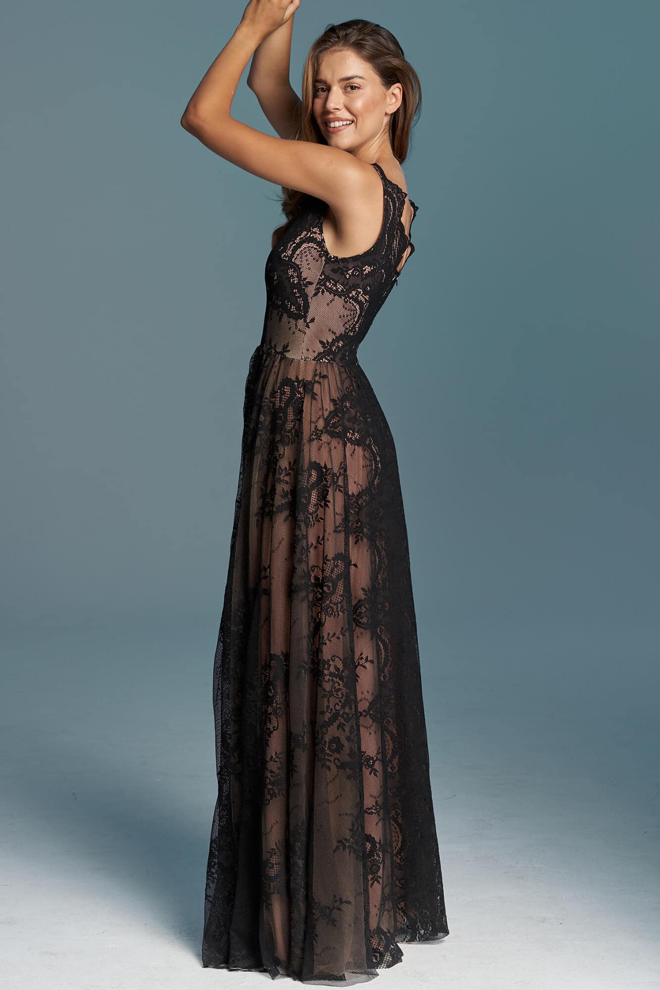 suknia z przezroczystego materiału z koronkowym wzorem, modelka w pozycji profilowej