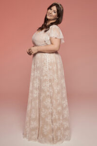 suknia ślubna z koronkowymi rękawami i delikatnym wzorem kwiatowym na jasnym tle