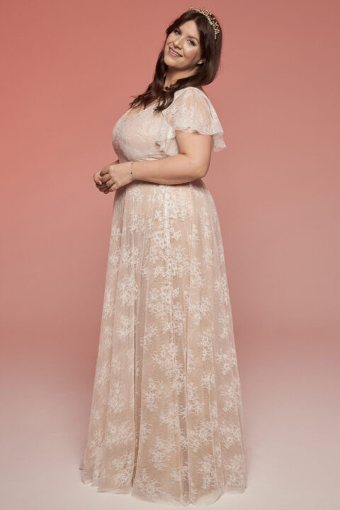 suknia ślubna z koronkowymi rękawami i delikatnym wzorem kwiatowym na jasnym tle