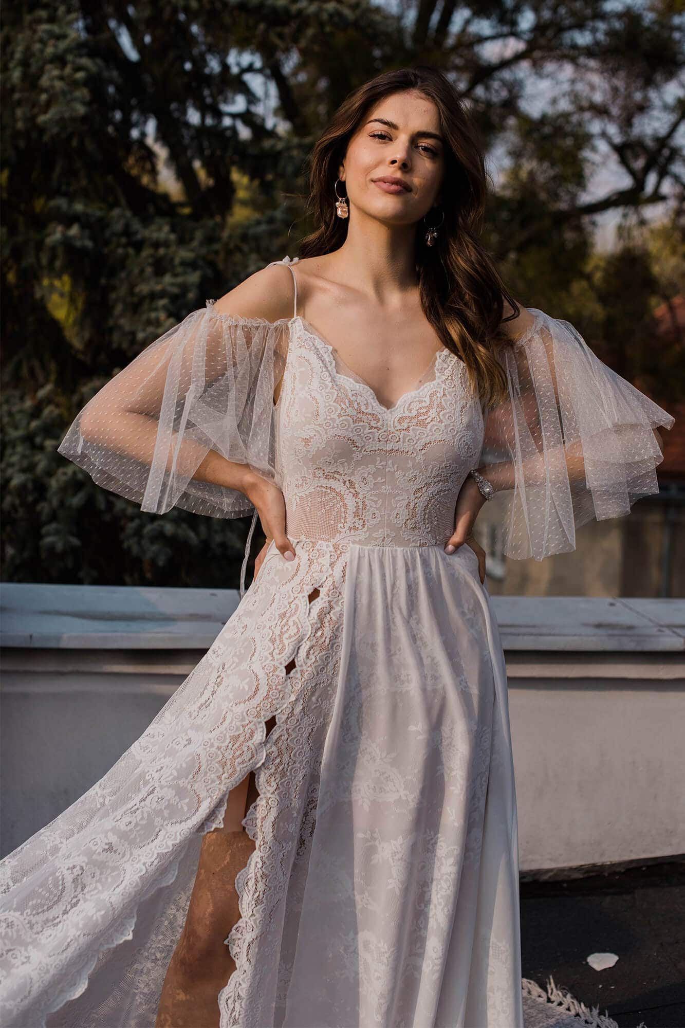 Suknia ślubna z koronkowym górnym fasonem i tiulowymi rękawami.