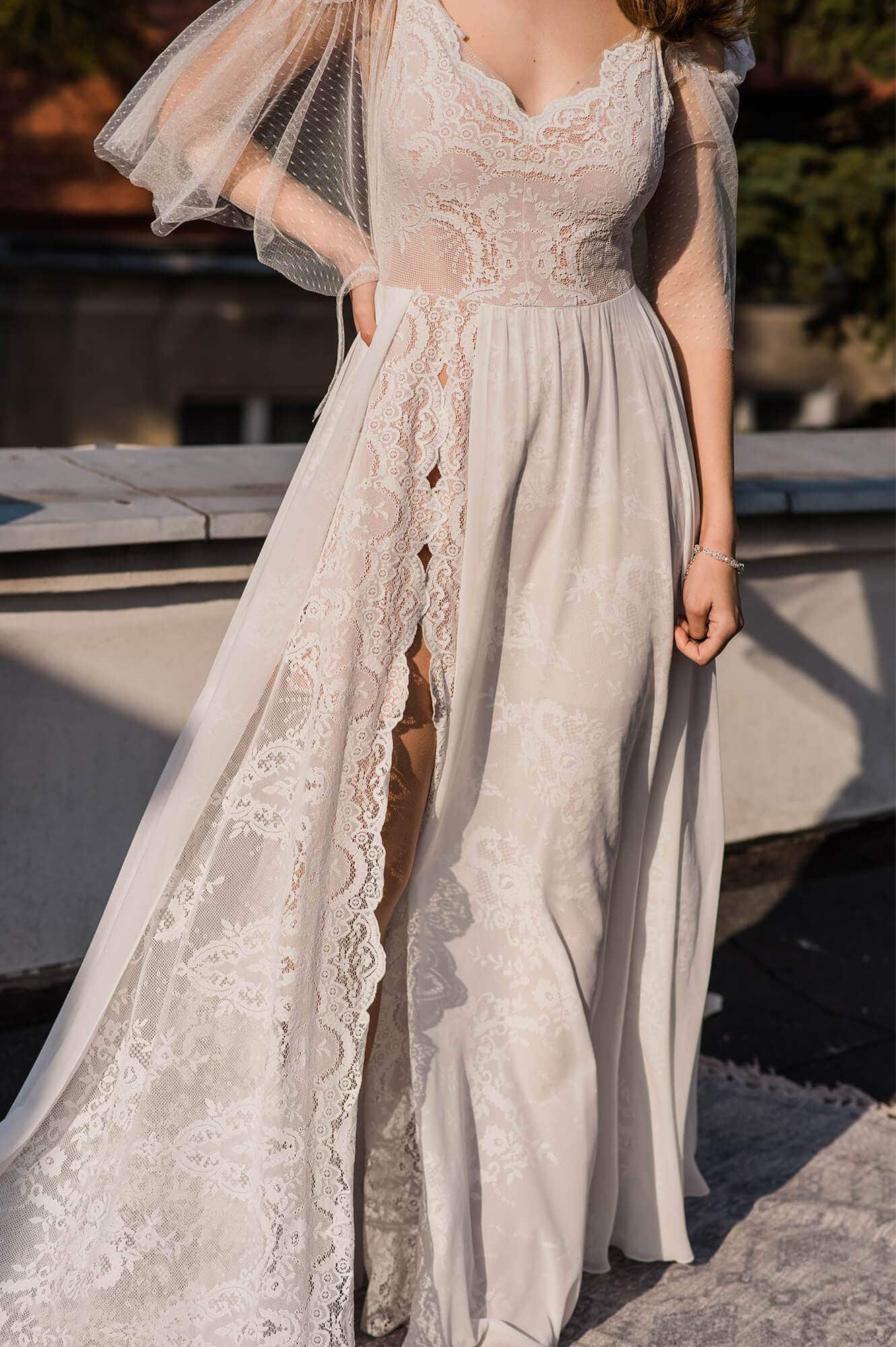 suknia ślubna z koronkowymi detalami i rozcięciem, z guzikami na przodzie