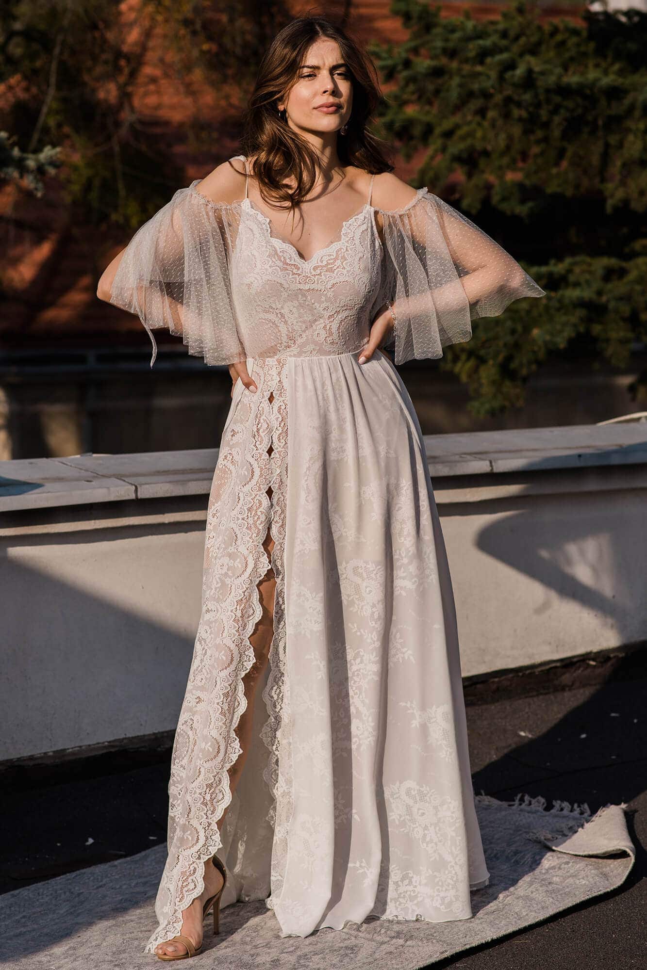 suknia ślubna z koronkowym wykończeniem, długimi rękawami i rozcięciem z przodu