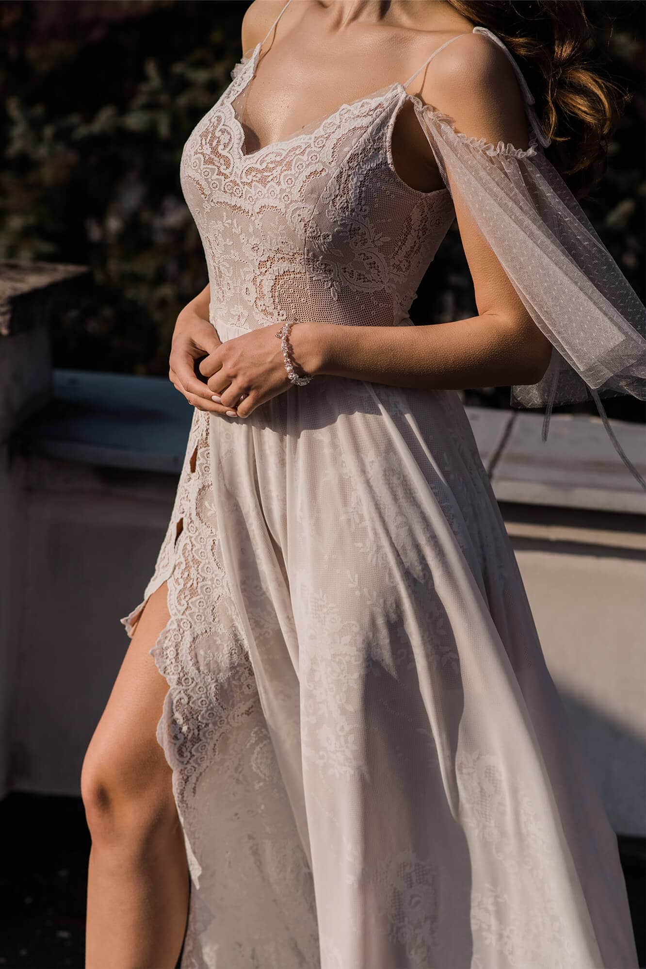 suknia ślubna z koronkowym górnym elementem i długim welonem, o zwiewnym dolnym fasonie