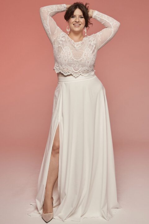 Suknia ślubna z koronkowym górnym elementem i rozcięciem na boku.