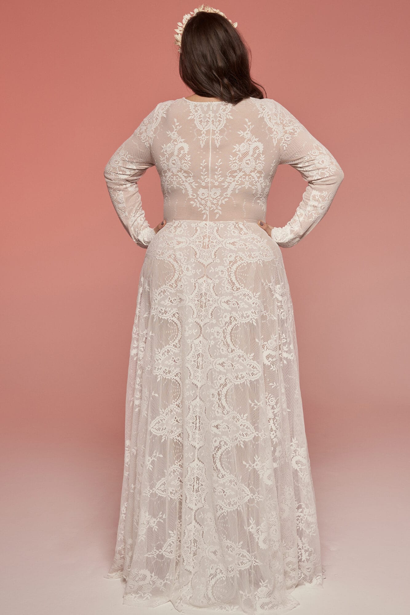 suknia ślubna z długim rękawem, wykonana z koronkowego materiału, widoczna z tyłu na modelce