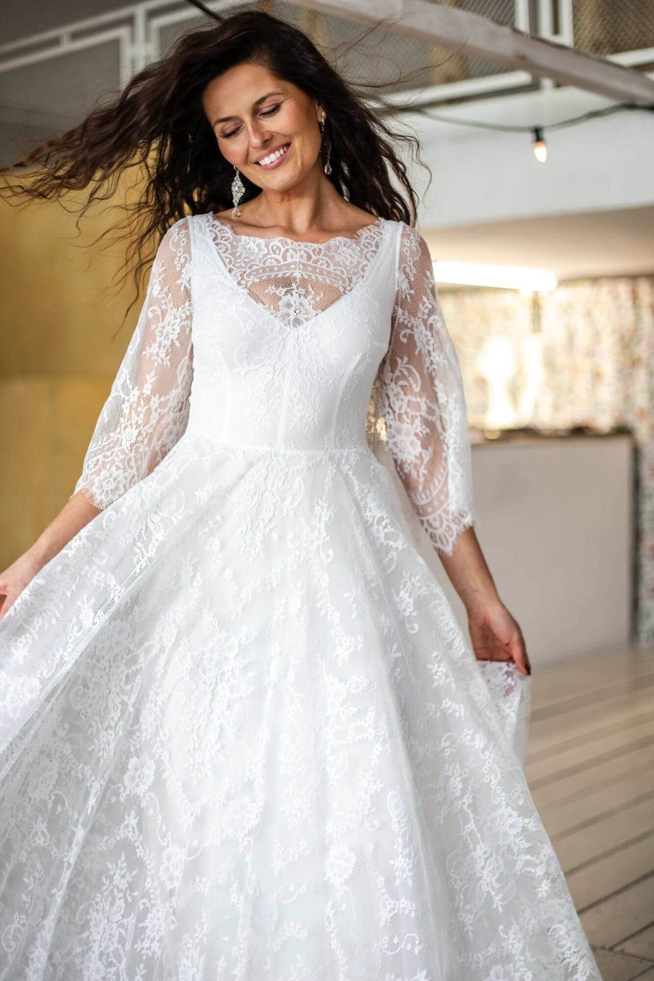 suknia ślubna z długimi koronkowymi rękawami i rozkloszowanym dołem w kolorze białym