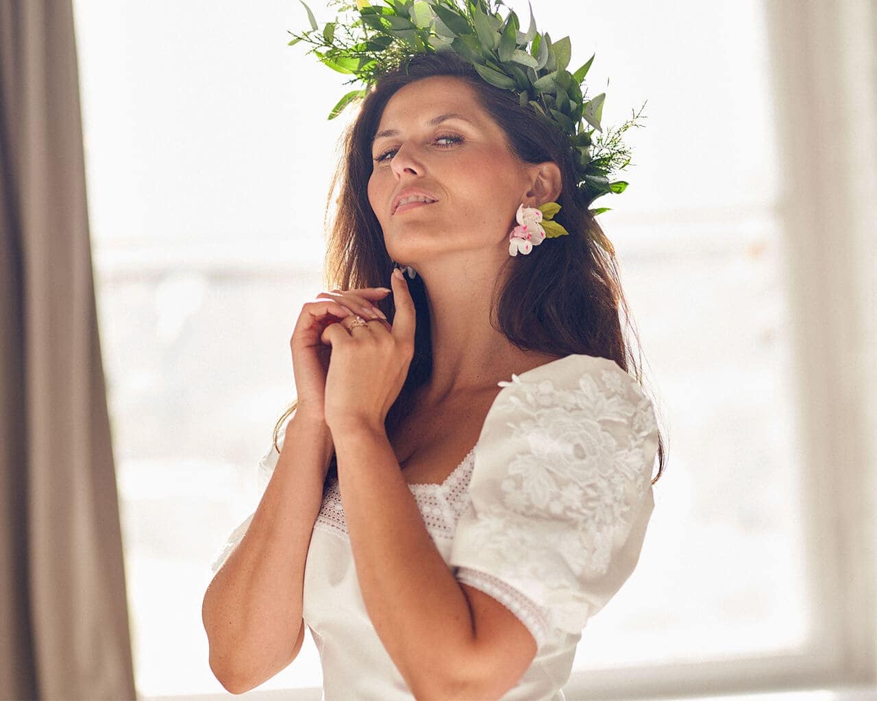 suknia ślubna z krótkim rękawem i koronkowymi detalami, modelka z kwiatową koroną na głowie