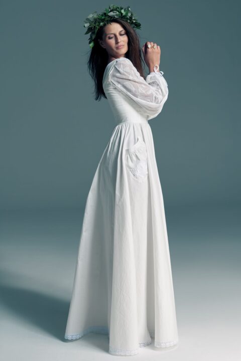 suknia ślubna w kolorze białym, z długimi rękawami i luźnym krojem.