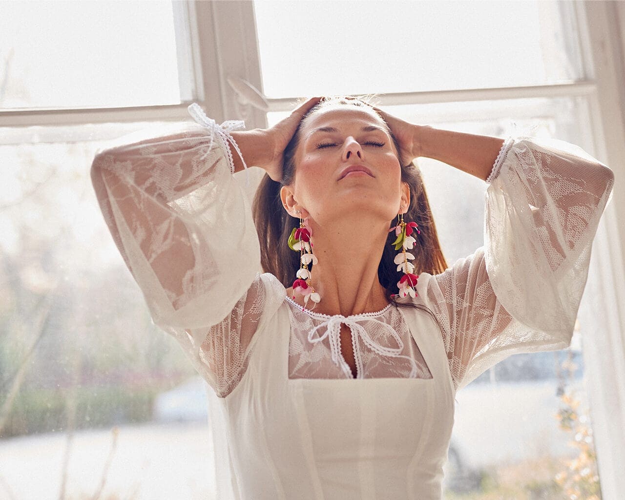 suknia z długimi rękawami i koronkowym wykończeniem, modelka z biżuterią w uszach