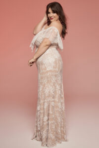 Suknia ślubna w kolorze jasnoróżowym z koronkowymi detalami i odkrytymi ramionami.