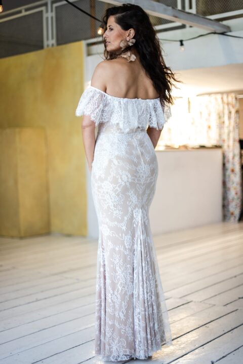 Suknia ślubna z koronkowym dekoltem i długim, dopasowanym dołem.