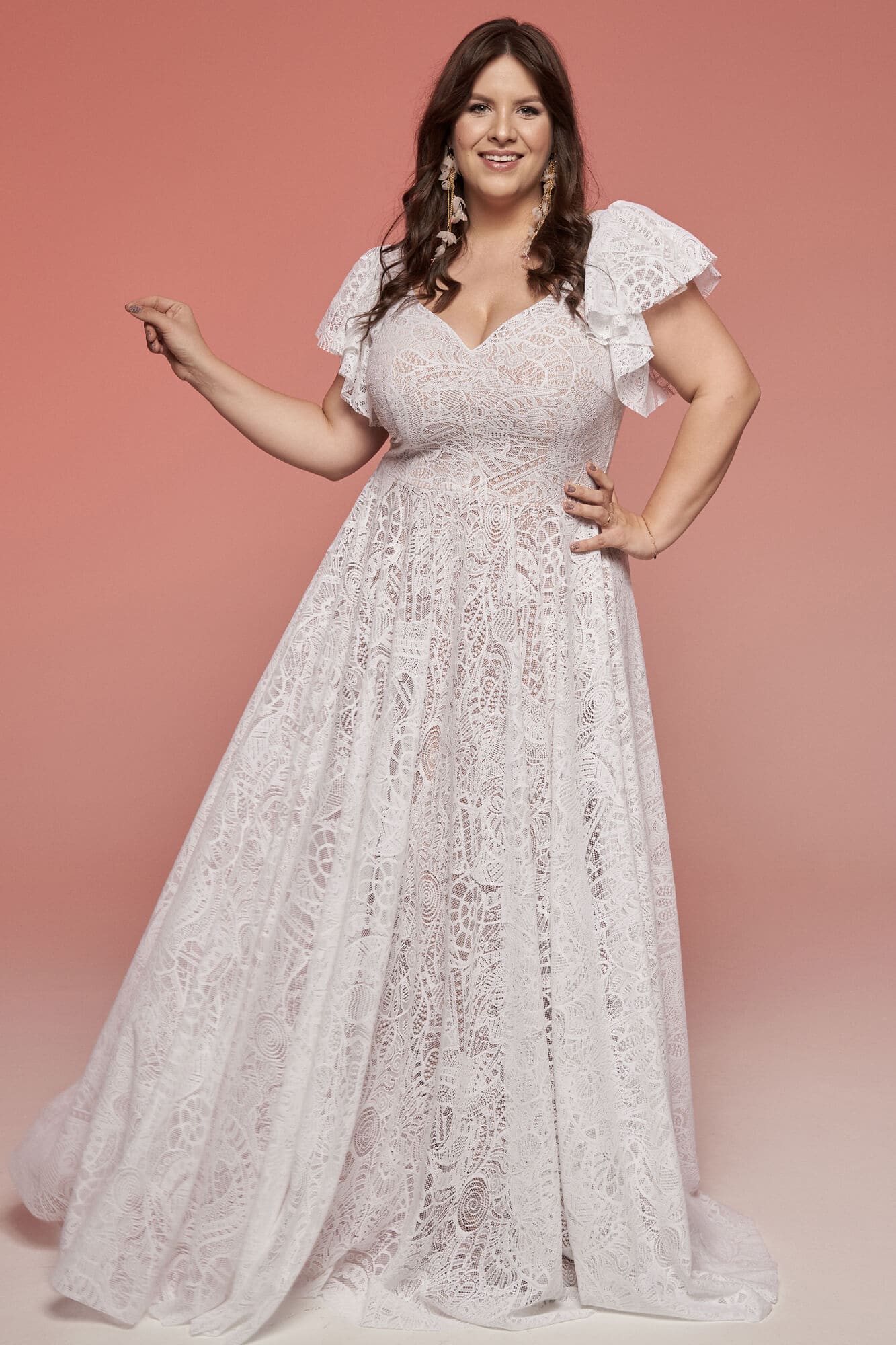 Suknia ślubna z koronkowymi rękawami i dekoltem w kształcie serca, w kolorze białym.