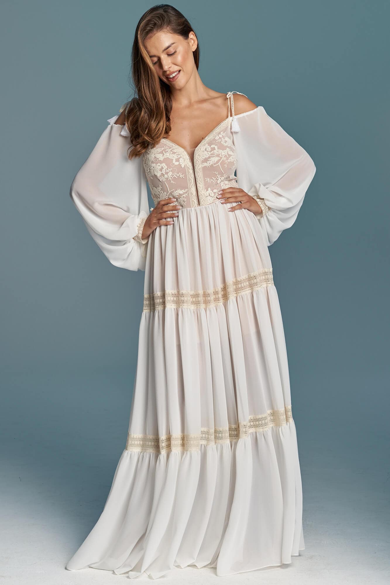 suknia ślubna z długimi rękawami, dekoltem w serek i ozdobnymi detalami w pasie