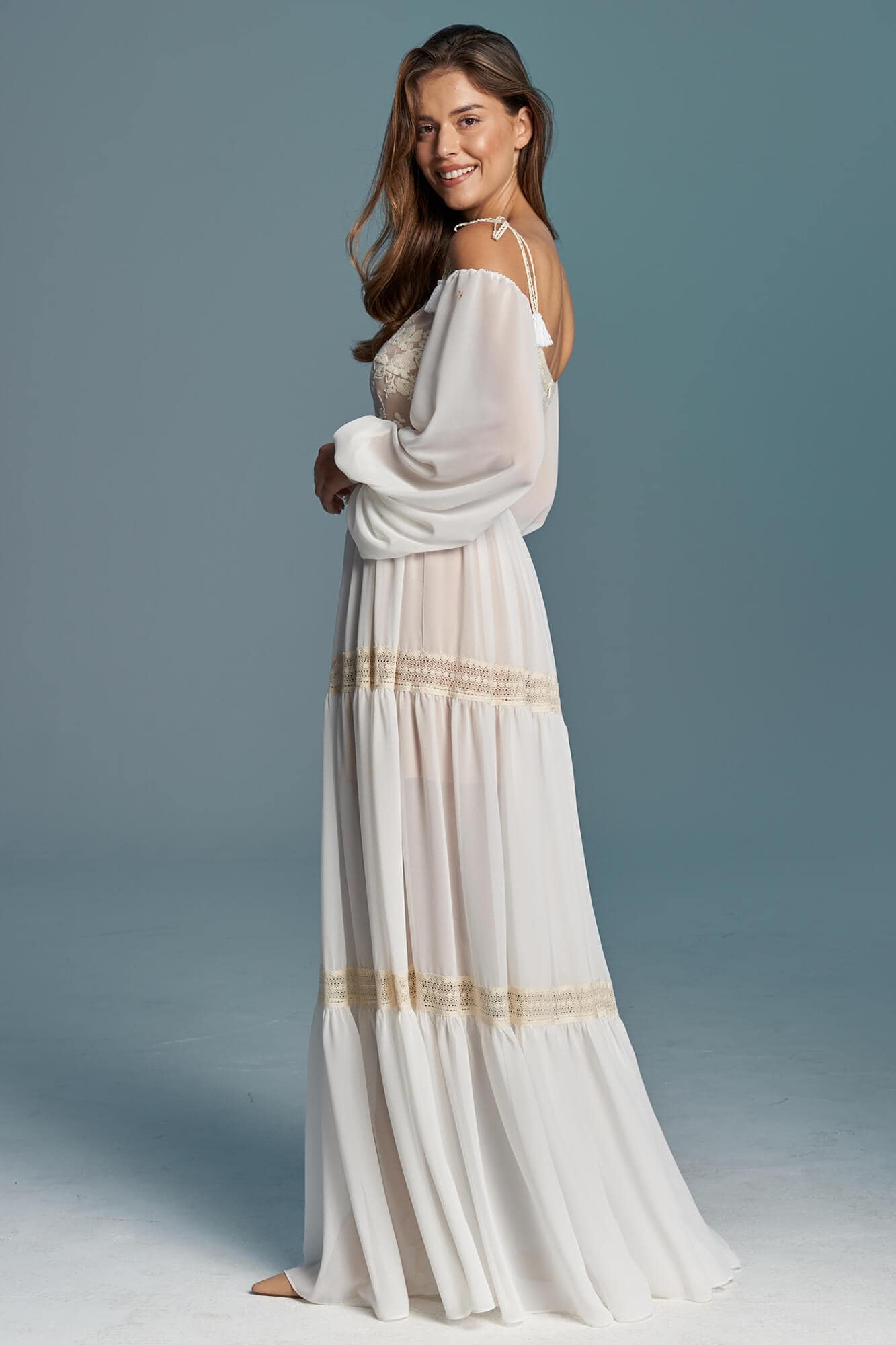 suknia ślubna z długimi rękawami, koronkowym wykończeniem i falbaniastym dołem w kolorze białym