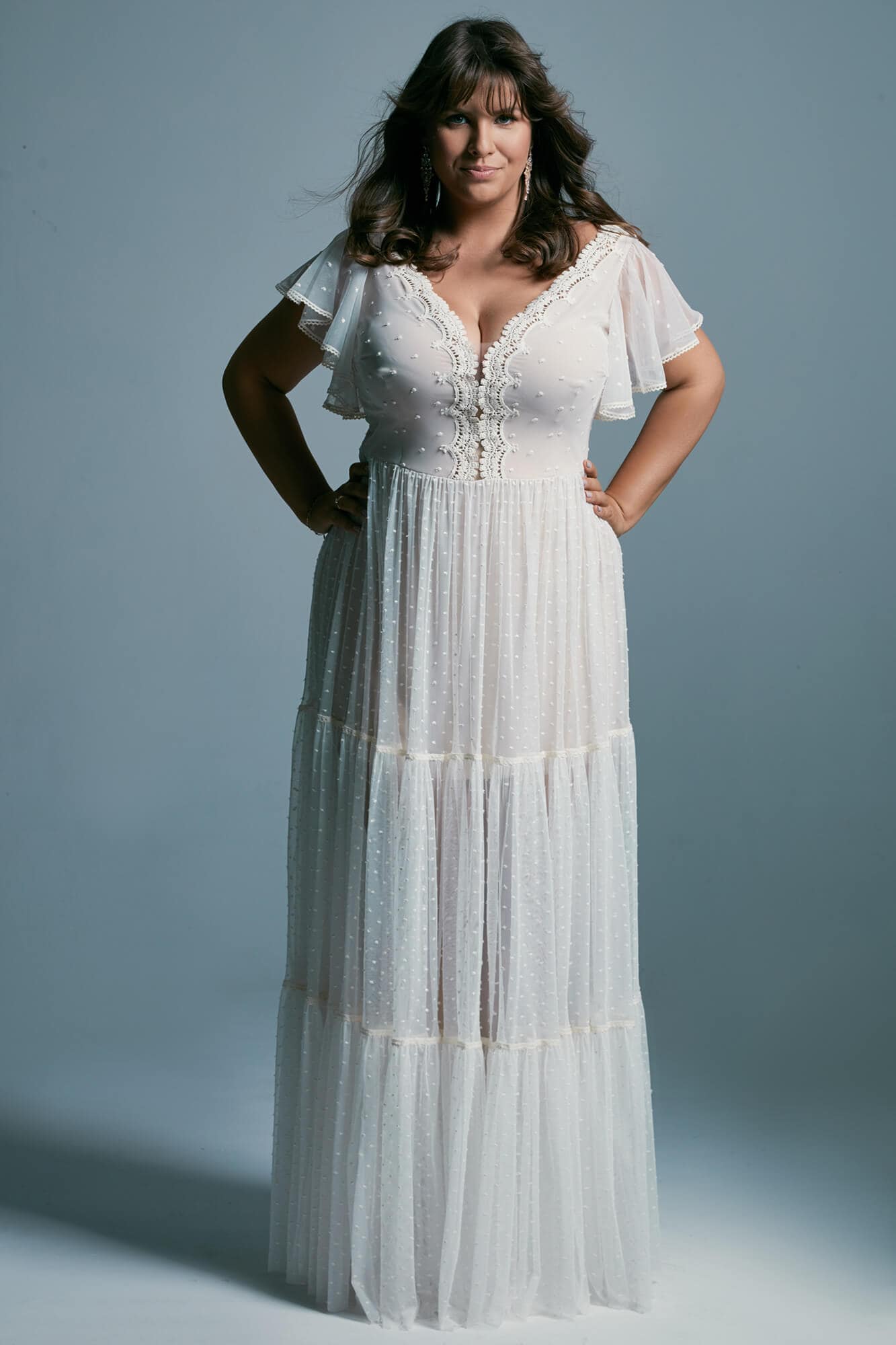 suknia ślubna z krótkimi rękawami, dekoltem w serek i falbanami, w kolorze białym.