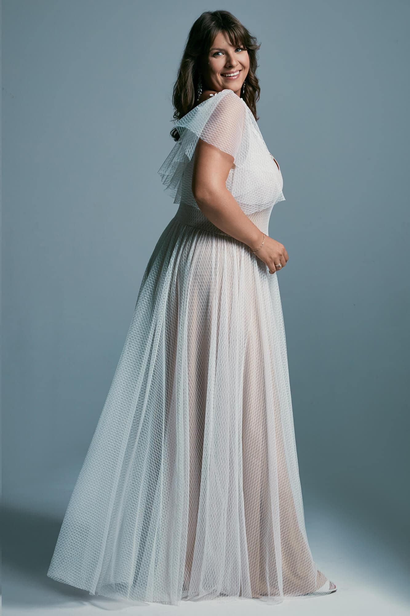 suknia ślubna z lekkim, przezroczystym materiałem i rękawami do łokci