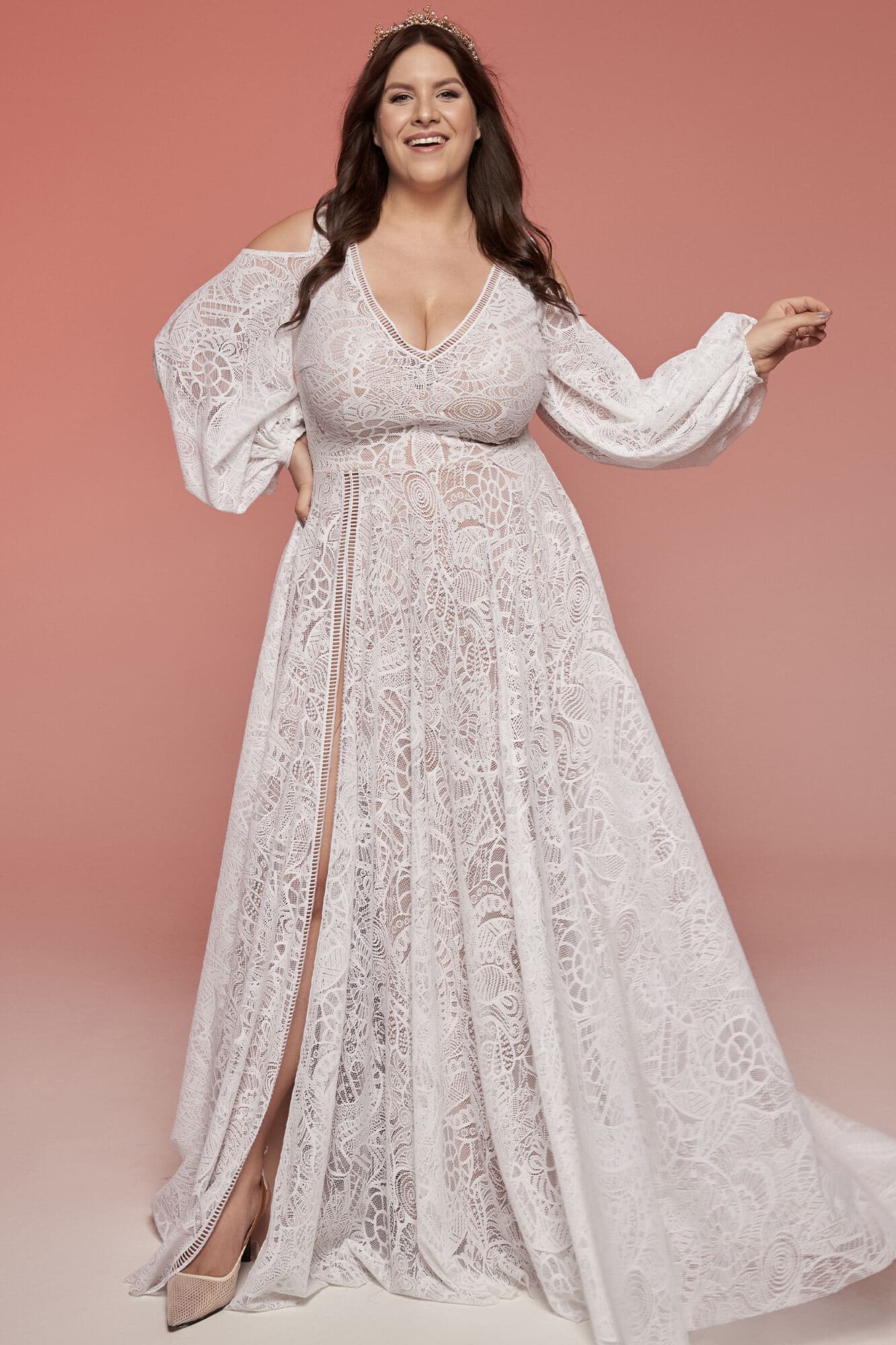 Suknia ślubna z długimi rękawami, zdobiona wzorem, w kolorze białym.