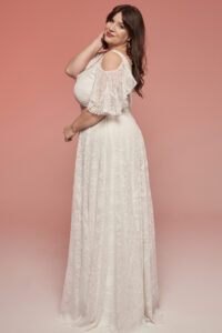 suknia ślubna z odkrytymi ramionami i koronkowym zdobieniem, w kolorze białym.