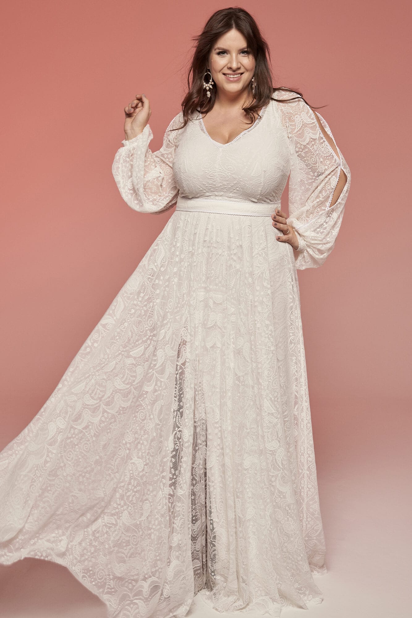 suknia ślubna z długimi rękawami, z delikatnym wzorem i rozkloszowanym dołem.