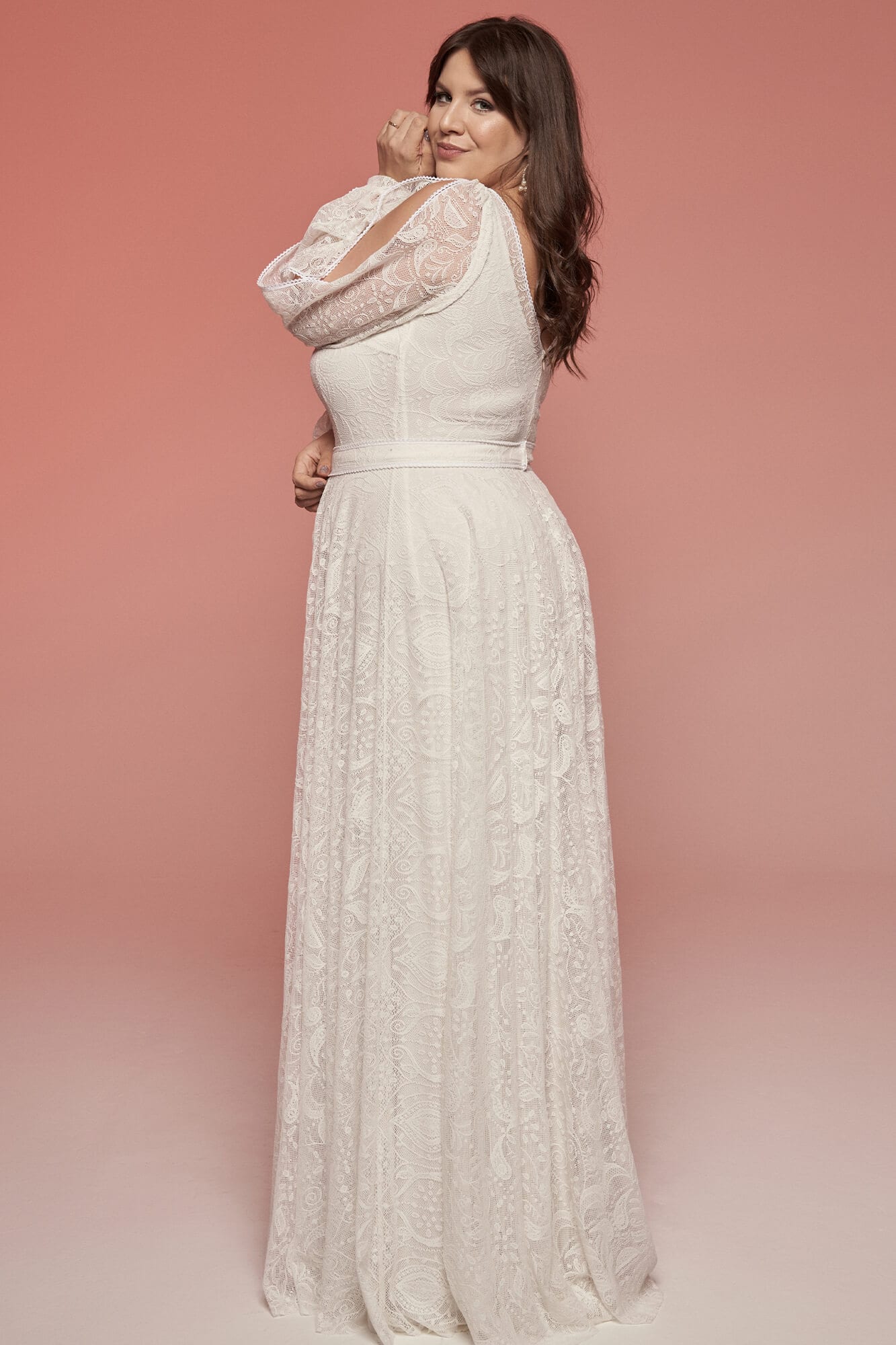 suknia ślubna w kolorze białym z koronkowymi detalami, z odkrytymi ramionami i długim dołem.