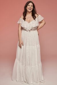 suknia ślubna z koronkowymi rękawami, rozkloszowana, w kolorze białym, modelka z koroną na głowie