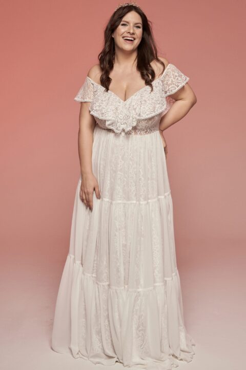 suknia ślubna z koronkowymi rękawami, rozkloszowana, w kolorze białym, modelka z koroną na głowie