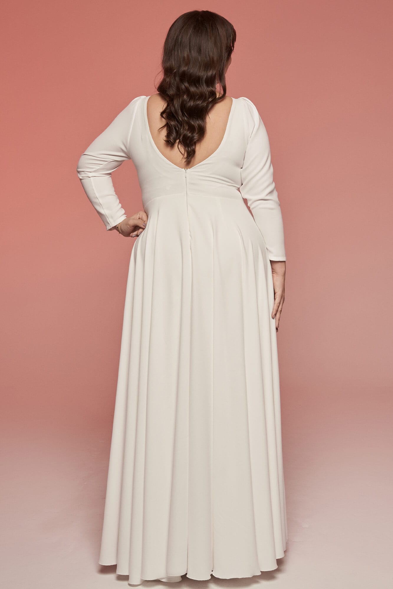 suknia ślubna z długim rękawem i głębokim dekoltem z tyłu, w kolorze białym.