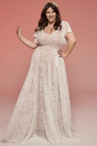 suknia ślubna w jasnym kolorze, z koronkowymi rękawami i długą spódnicą