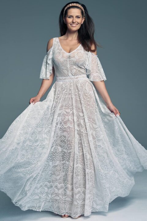 Suknia ślubna z koronkowym wzorem, z rękawami w kształcie dzwonu i rozkloszowanym dołem.