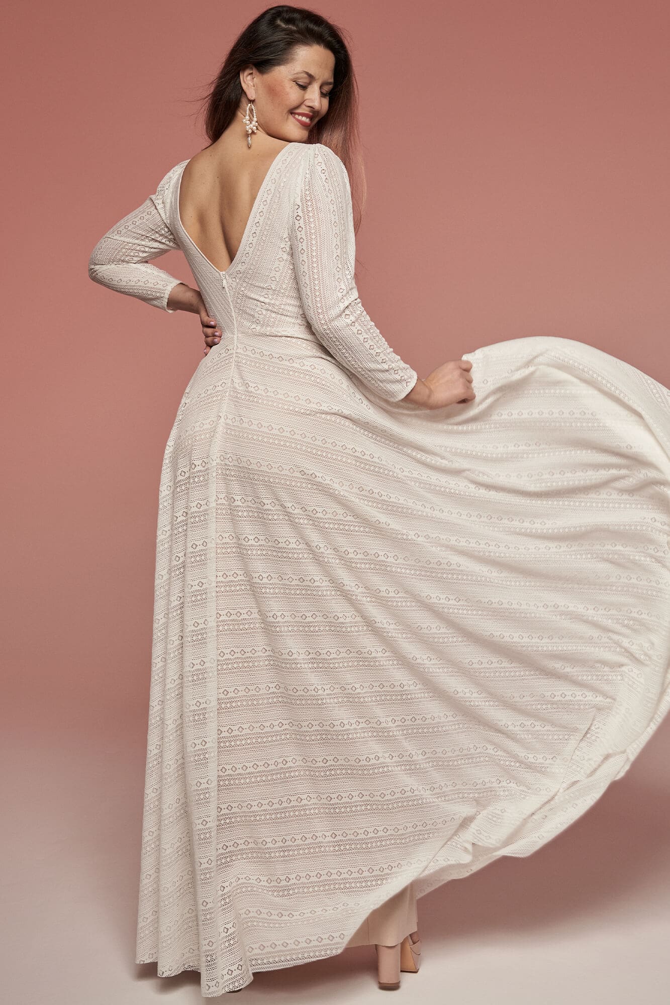 Suknia ślubna z długimi rękawami, z dekoltem w serek i wzorem w paski.