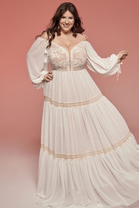 suknia ślubna o długich rękawach, z koronkowym dekoltem i złotymi detalami.