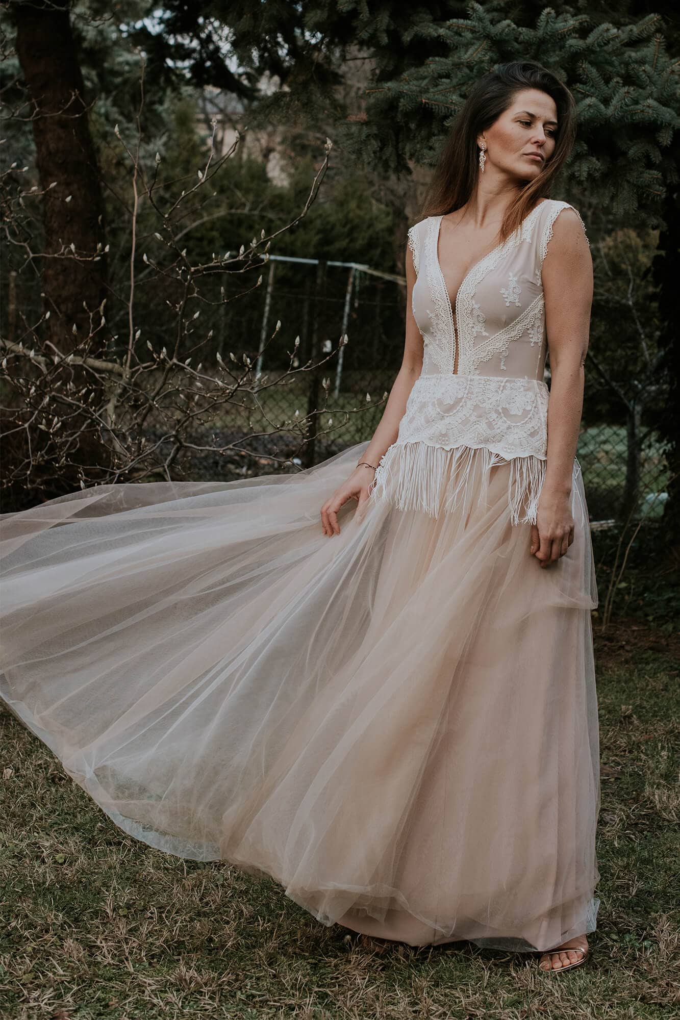 Suknia ślubna z koronkowym gorsetem i zwiewnym tiulowym dołem w odcieniu nude.